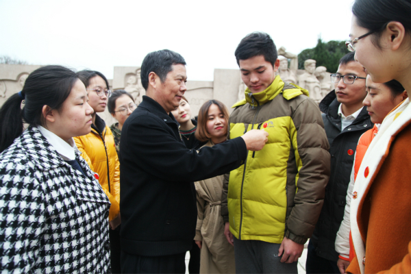 图为教科院党委书记周友士为学生党员佩戴党徽。记者 戴云 摄.jpg